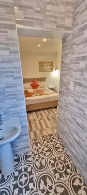 a bathroom with a sink and a bed in a room at Neo & Ruks Guest Houses Boston Belleville 6 in Bellville