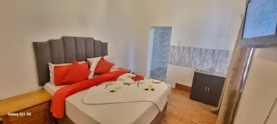 a bedroom with a bed with orange pillows at Neo & Ruks Guest Houses Boston Belleville 6 in Bellville