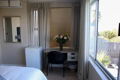 a bedroom with a desk with a vase of flowers on it at Tygerviews on Uys in Tygerberg Hills