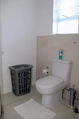 a bathroom with a toilet and a trash can at Tygerviews on Uys in Tygerberg Hills