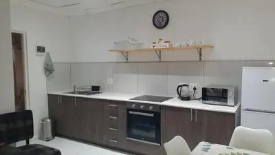 a kitchen with a stove and a refrigerator at Comfey Stay in Somerset West
