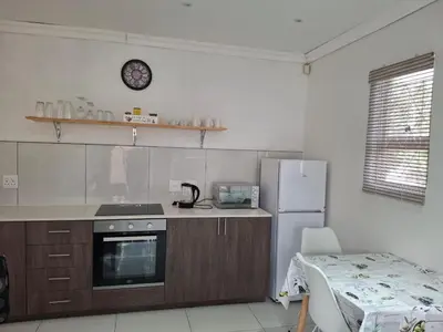 a kitchen with a stove and a refrigerator at Comfey Stay in Somerset West