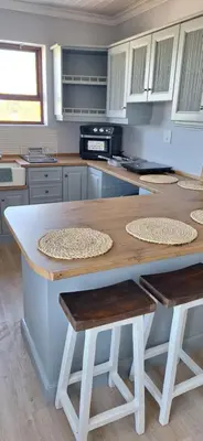 a kitchen with a table and two stools at 33 on Vermont in Hermanus