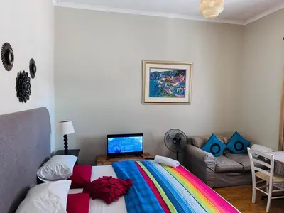 a bedroom with a colorful bed and a couch at Peaceful getaway in Cape Town