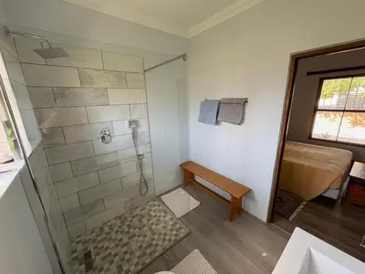 a bathroom with a shower with a bench and a sink at Cozy en-suite room in Wellington with own entrance in Wellington
