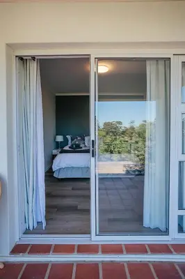 a room with sliding glass doors leading to a bedroom at On Helderberg in Somerset West