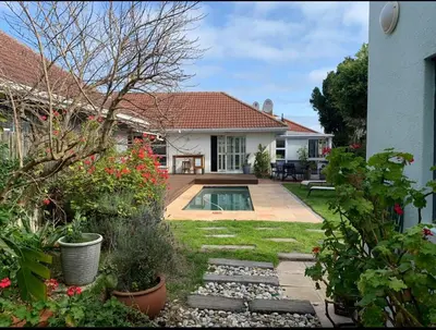 a house with a swimming pool in a yard at Crinum House and cottages in Bloubergstrand in Cape Town