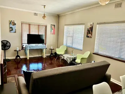 a living room with a couch and a television at One Bedroom House in Goodwood