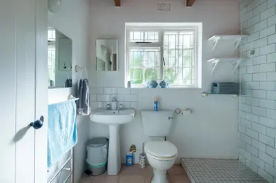 a white bathroom with a toilet and a sink at Serendipity Self-Catering Cottage in Greyton