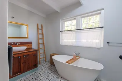 a bathroom with a large tub and a sink at Serendipity Self-Catering Cottage in Greyton