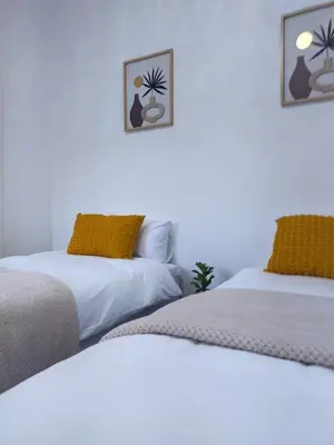 a room with two beds and two pictures on the wall at 60 On Kosmos in Bellville South