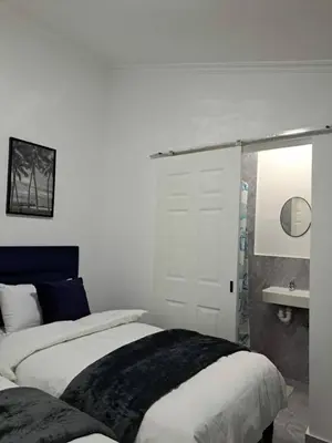 a white bedroom with a bed and a bathroom at 60 On Kosmos in Bellville South