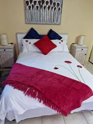 a bed with a red and white blanket on it at 22 on Shiraz in Hoheizen