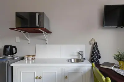 a kitchen with a sink and a microwave at Twelve on Arum in Somerset West
