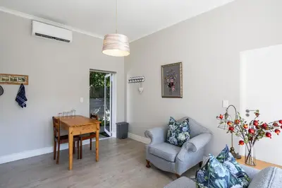 a living room with a table and a chair at Twelve on Arum in Somerset West