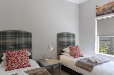 a bedroom with two beds and a window at Twelve on Arum in Somerset West