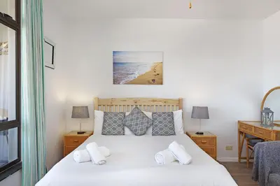 a bedroom with a bed and a desk at Witsand 303 in Cape Town
