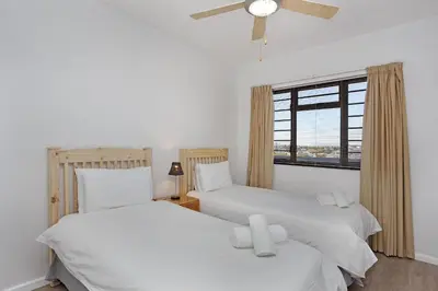 two beds in a room with a window at Witsand 303 in Cape Town