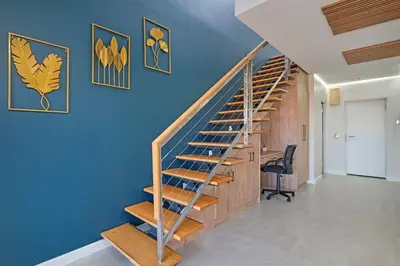 a wooden staircase in a room with a blue wall at Ultra Luxury 3 Bed Knightsbridge Penthouse in Cape Town