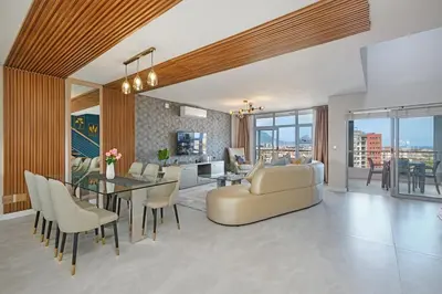 a living room with a couch and a dining room at Ultra Luxury 3 Bed Knightsbridge Penthouse in Cape Town