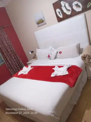 a bedroom with a white bed with a red blanket at Neo & ruks guest houses Boston Belleville 4 in Bellville