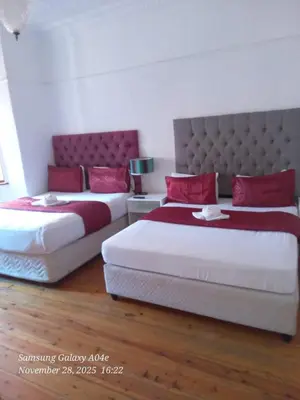 two beds with red pillows in a bedroom at Neo & ruks guest houses Boston Belleville 4 in Bellville