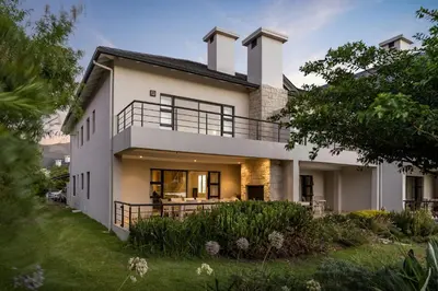 a large white house with a yard at Pearl Valley family golf lodge on nature lake with mountain views in Simondium