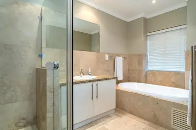 a bathroom with a tub and a sink and a shower at Pearl Valley family golf lodge on nature lake with mountain views in Simondium