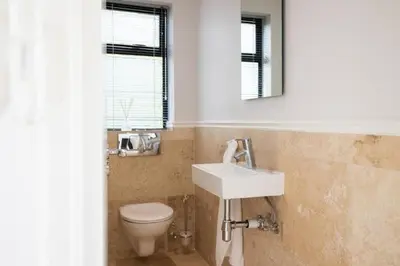a bathroom with a sink and a toilet at Pearl Valley family golf lodge on nature lake with mountain views in Simondium