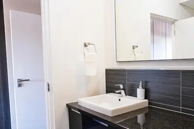 a bathroom with a white sink and a mirror at 126 Andringa Walk in Stellenbosch