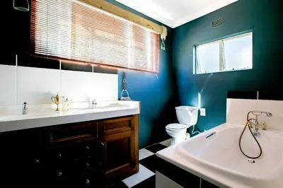 a bathroom with a sink and a tub and a toilet at Courchevel Cottages in Franschhoek