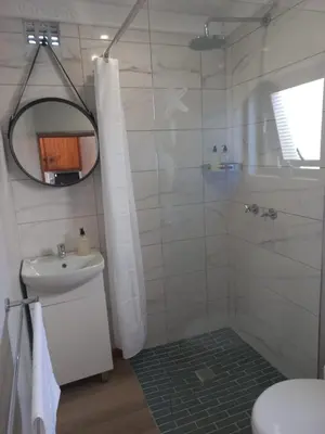 a bathroom with a shower and a sink at Rosa Villa in Hermanus