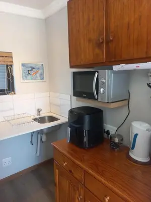 a kitchen with a microwave and a sink at Rosa Villa in Hermanus