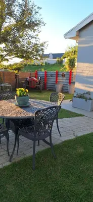 a patio table with a bowl of flowers on it at Firehouse selfcatering Garden Cottage no 1 in Wellington