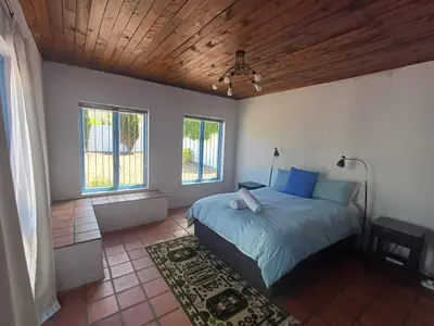 a bedroom with a bed and a wooden ceiling at Holiday Vibe in Hermanus