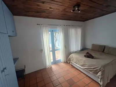 a bedroom with a bed in a room with a window at Holiday Vibe in Hermanus