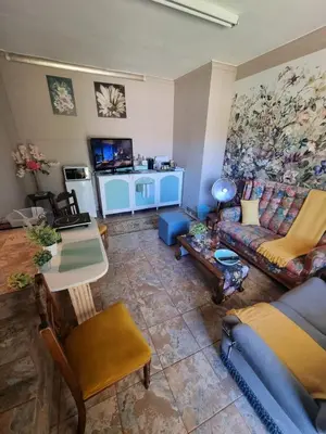 a living room with a couch and a table at UITZICHT STAY Durbanville Pet Friendly in Oakdale