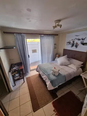 a bedroom with a bed with a teddy bear on it at UITZICHT STAY Durbanville Pet Friendly in Oakdale