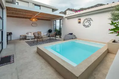a swimming pool in the middle of a patio at Fun in the Voelklip Sun in Hermanus