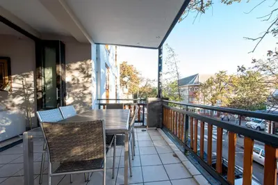 a patio with a table and chairs on a balcony at Oude Hoek, Stellenbosch Central in Stellenbosch