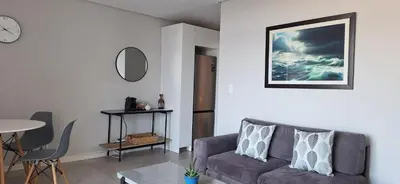 a living room with a couch and a table at Sound of the surf in Cape Town