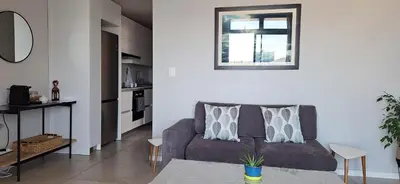a living room with a couch and a window at Sound of the surf in Cape Town