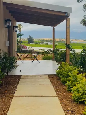 a covered porch with a table and a bench at Self Check-in River View Suite in Wellington