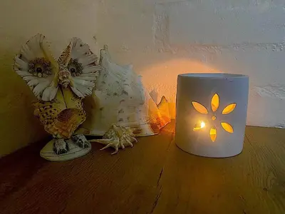 a white coffee cup sitting on a table with flowers at The Loft House in Cape Town