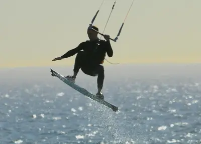 a man in the air on a surfboard in the water at The Loft House in Cape Town