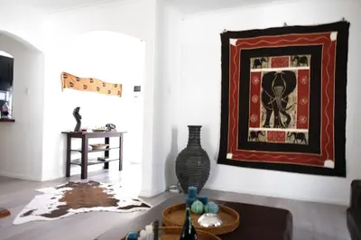 a living room with a table and a picture on the wall at Villa on Flamingo Vlei in Cape Town