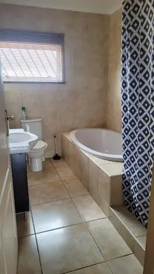 a bathroom with a tub and a toilet and a sink at Judea Accommodation in Bettyʼs Bay