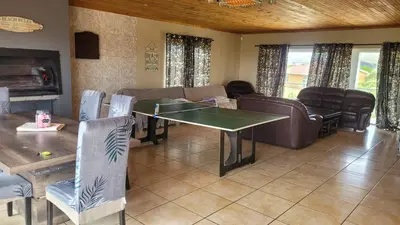 a living room with a ping pong table and couch at Judea Accommodation in Bettyʼs Bay