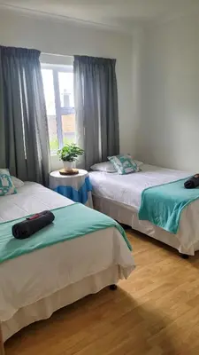 a bedroom with two beds and a window at Judea Accommodation in Bettyʼs Bay