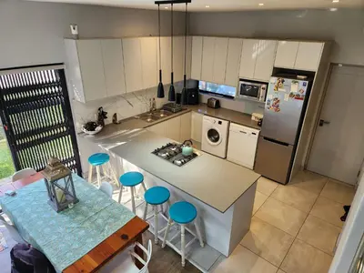 an overhead view of a kitchen with a table and chairs at St James home in Somerset West